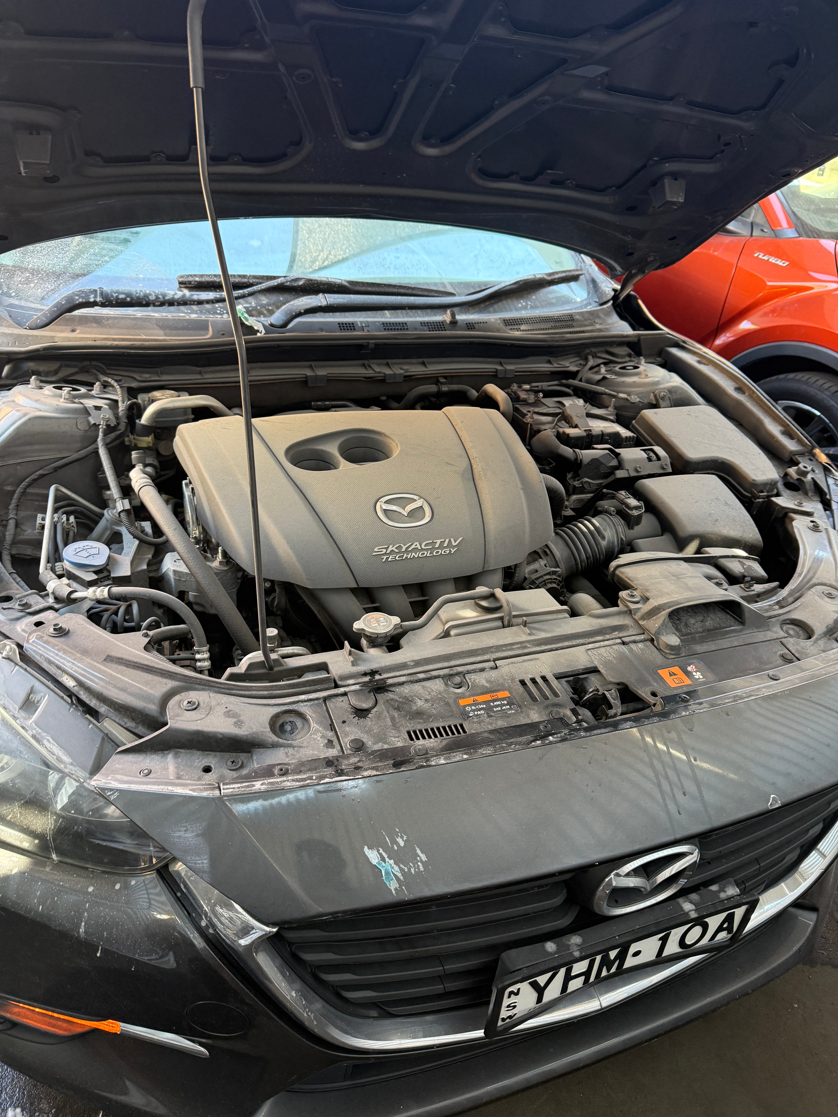 Mazda engine bay before detail — dirty